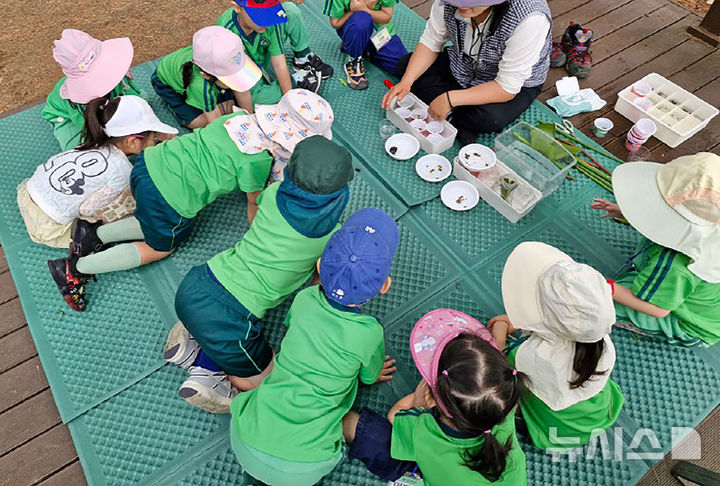 [성남=뉴시스] 경기 성남지역 유치원생들이 탄천 수내습지생태원에서 수생곤충 관찰 중이다. (사진=성남시 제공) 2026.08.20. photo@newsis.com 