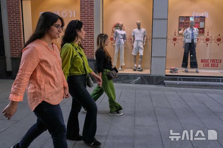 [AP/뉴시스] 20일 이란 수도 테헤란 북부 시장 모습으로 여성들이 의류 상점 앞을 지나고 있다