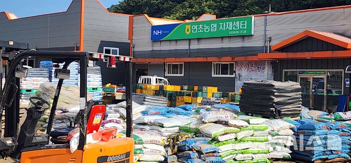 [거제=뉴시스] 김기진 기자 = 21일 최근 극한 호우로 수해를 겪은 경남 거제시 연초농협 자재센터 앞에 침수 피해를 입은 비료, 생수, 쌀, 소금 등 연초농협 자재품들이 쌓여 있다. 2026.08.21.sky@newsis.com