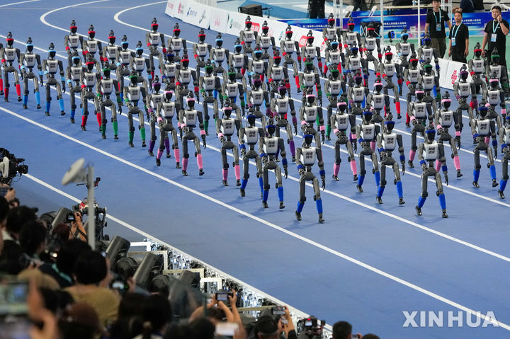 [베이징=신화/뉴시스] 22일 중국 베이징에서 열린 제2회 세계휴머노이드로봇운동회 개막식에서 휴머노이드 로봇들이 행진하고 있다. 2026.08.23