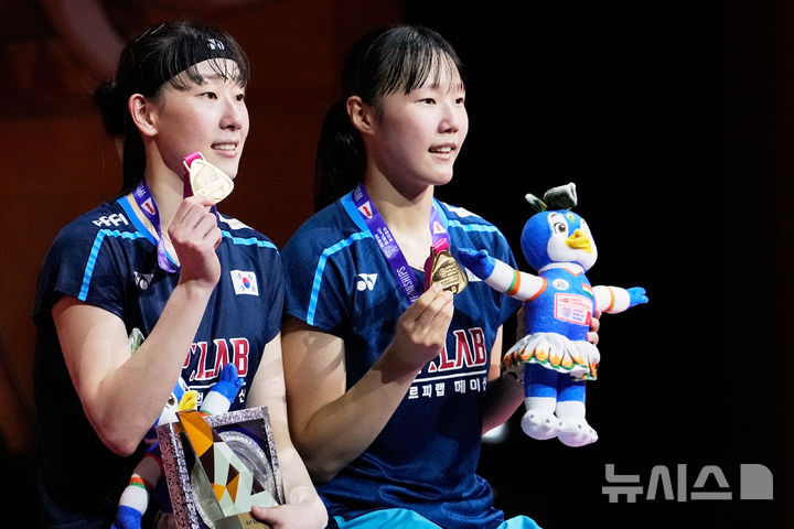[뉴델리=AP/뉴시스] = 이소희-백하나가 23일(한국시간) 인도 뉴델리에서 열린 2026 세계배드민턴연맹(BWF) 세계선수권대회 여자 복식에서 우승을 차지한 뒤 금메달을 들어보이고 있다. 2026.08.23.