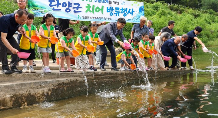 쏘가리 치어 방류하는 어린이들(사진=단양군 제공) *재판매 및 DB 금지