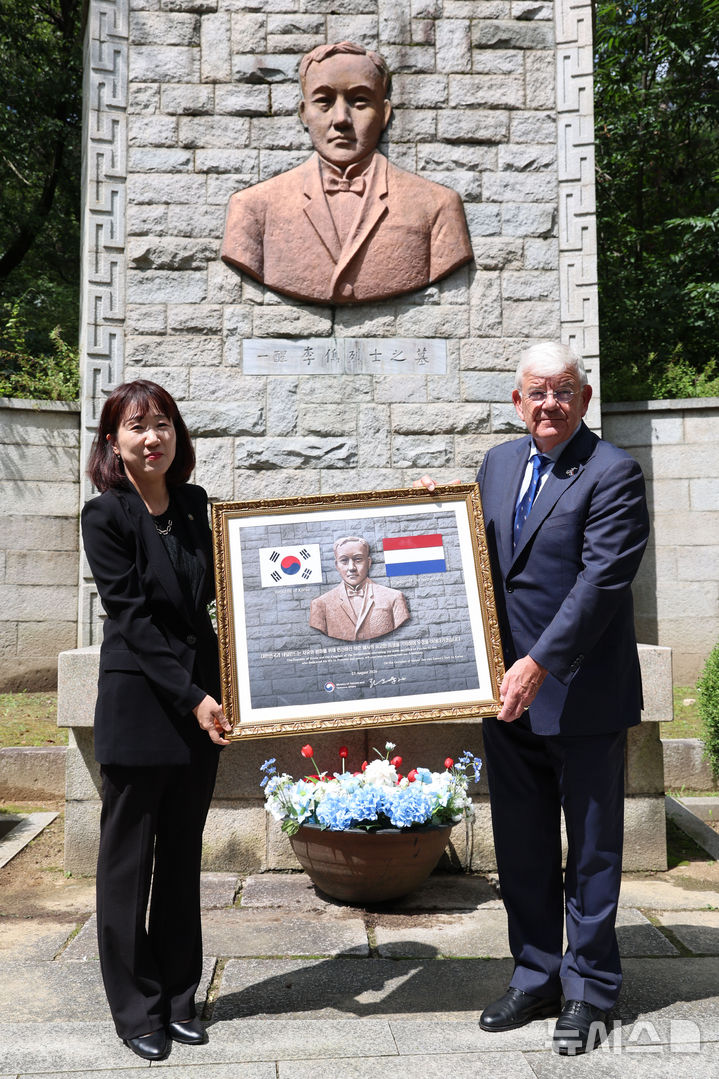 [서울=뉴시스] 권창회 기자 = 강윤진(왼쪽) 국가보훈부 차관이 23일 서울 강북구 수유 국가관리묘역 내 이준 열사 묘역에서 참배를 마친 뒤 얀 판자넌 네덜란드 헤이그시 시장에게 기념품을 전달하고 있다. 이번 참배는 1907년 고종 황제의 특사로 네덜란드 헤이그 만국평화회의에 파견돼 대한제국의 자주독립을 호소하다 순국한 이준 열사를 기리고 양국 간 역사적 유대와 평화의 가치를 되새기기 위해 마련됐다. 2026.08.23. kch0523@newsis.com