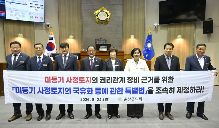 [순창=뉴시스] 24일 개회한 순창군의회 제305회 임시회 제1차 본회의, 오수환 의장(왼쪽 네번째)을 비롯한 군의원들이 한소용 의원(왼쪽 다섯번째) 발의한 '미등기 사정토지의 국유화 등에 관한 특별법 제정 촉구 건의안'을 채택한 후 법령제정을 촉구하는 현수막과 사진을 찍고 있다. *재판매 및 DB 금지