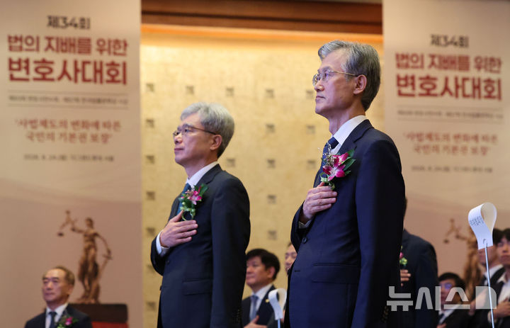[서울=뉴시스] 권창회 기자 = 조희대(오른쪽) 대법원장과 김상환 헌법재판소장이 24일 서울 중구 더그랜드롯데 서울에서 열린 제34회 법의 지배를 위한 변호사대회에서 국민의례를 하고 있다. 2026.08.24. kch0523@newsis.com