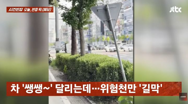 [서울=뉴시스] 충남 천안의 한 횡단보도에서 남성이 보행 신호가 끝난 뒤에도 차량 통행을 막는 모습이 포착됐다. (사진=JTBC '사건반장' 캡처)