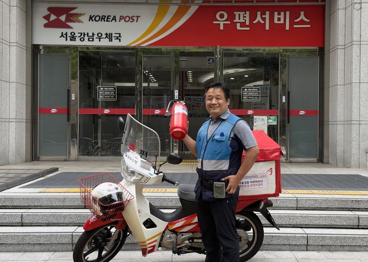 [서울=뉴시스]서울강남우체국 소속 임승만 집배원이 지난 20일 서울 강남구 대모산역 사거리 인근에서 화재가 발생한 화물차의 운전자를 대피시키고 직접 불을 진압했다. (사진=우정사업본부 제공) *재판매 및 DB 금지