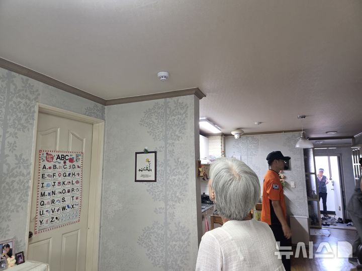 [전주=뉴시스] 강경호 기자 = 26일 전북 전주시 완산구의 한 아파트에 설치된 시청각경보감지기를 거주자 이정숙씨가 유심히 들여다보고 있다. 2026.08.26. lukekang@newsis.com