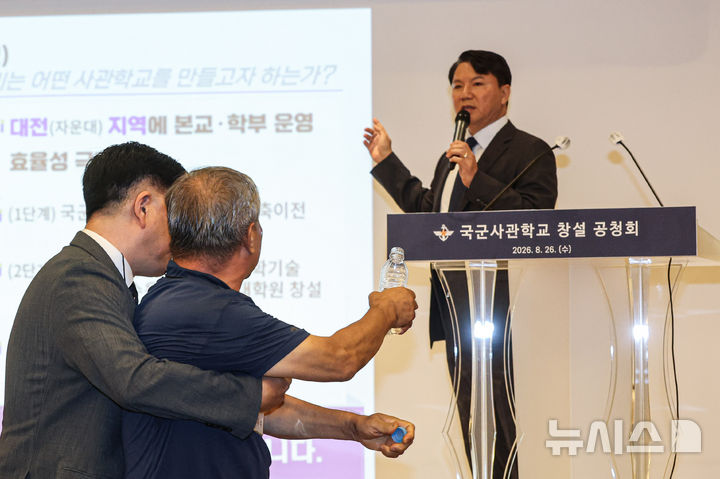 [서울=뉴시스] 전신 기자 = 26일 오후 서울 용산구 국방컨벤션에서 열린 국군사관학교 창설 공청회에서 한 참석자가 생수병을 든 채 발언하고 있는 김홍철 국방부 정책실장에게 다가서고 있다. (공동취재) 2026.08.26. photo1006@newsis.com