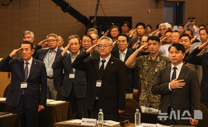 [서울=뉴시스] 전신 기자 = 26일 오후 서울 용산구 국방컨벤션에서 열린 국군사관학교 창설 공청회에서 김홍철(앞줄 오른쪽부터) 국방부 정책실장, 박판준 육군사관학교 총동창회장, 이범림 해군사관학교 총동창회장 등 참석자들이 국기에 경례하고 있다. (공동취재) 2026.08.26. photo1006@newsis.com