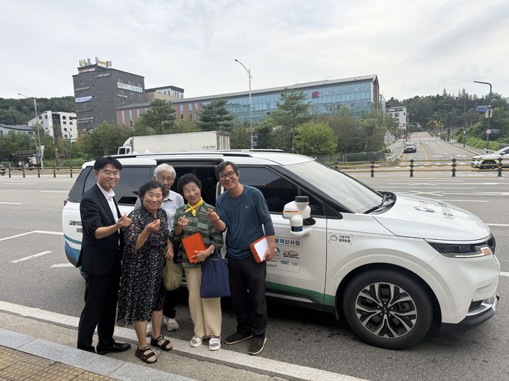 [화성=뉴시스] 26일 자율주행 리빙랩 시민설명회 참석자들이 교통약자 이동지원 자율주행 차량을 시승한 뒤 기념촬영을 하고 있다. (사진=화성시 제공) 2026.08.27. photo@newsis.com *재판매 및 DB 금지
