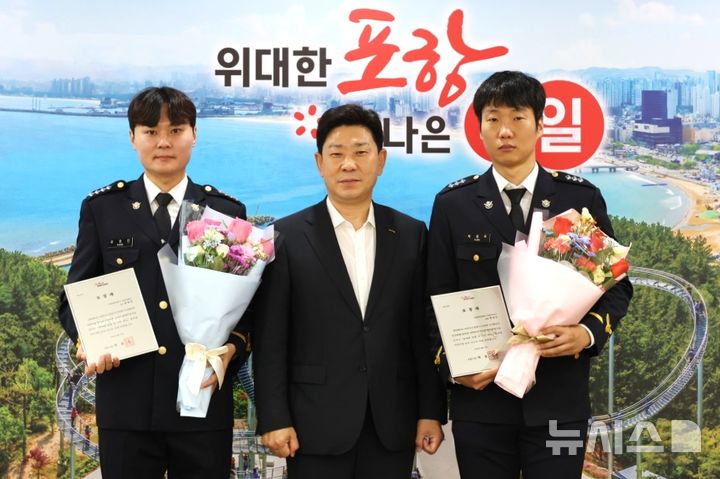 [포항=뉴시스] 포항시는 27일 시청 대외협력실에서 보릿돌교 붕괴 사고 현장에서 인명 구조에 앞장선 포항해양경찰서 경찰관 2명에게 표창을 전달한 후 강호민(사진 왼쪽부터) 경사, 박용선 시장, 박성우 경장이 기념 촬영하고 있다. (사진=포항시 제공) 2026.08.27. photo@newsis.com