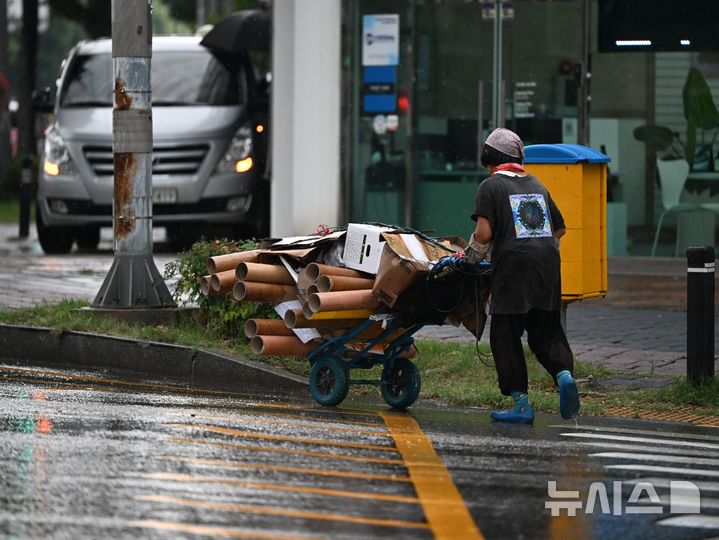 [전남광주=뉴시스] 이현행 기자 = 27일 오후 전남광주통합특별시 동구 계림동 한 도로에서 리어카를 끄는 어르신이 비를 맞으며 횡단보도를 건너고 있다. 2026.08.27. lhh@newsis.com