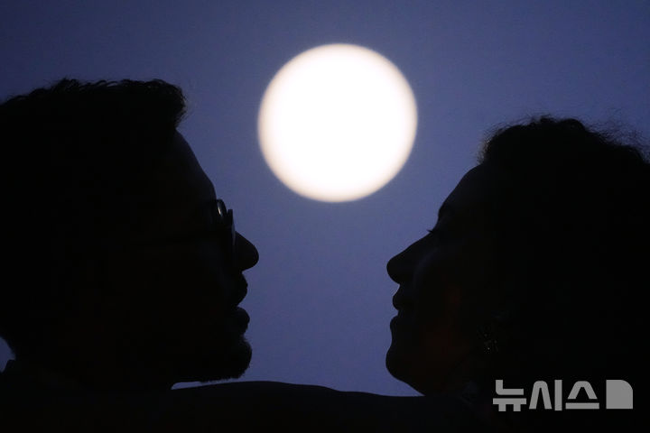 [리스본=AP/뉴시스] 27일(현지 시간) 포르투갈 리스본 산타 루지아 전망대에서 한 연인이 부분월식을 앞둔 보름달을 바라보며 포옹하고 있다. 2026.08.28.
