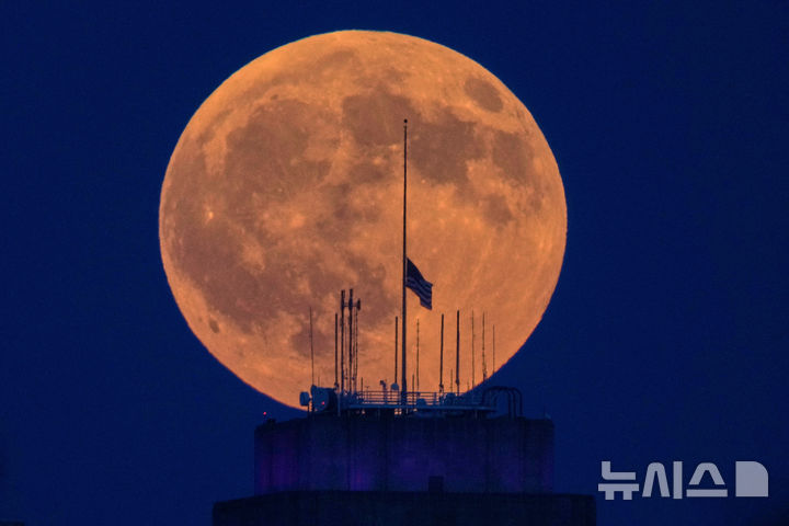 [캔자스시티=AP/뉴시스] 27일(현지 시간) 미 미주리주 캔자스시티 시청사 너머로 월식을 앞둔 보름달이 떠오르고 있다. 2026.08.28.