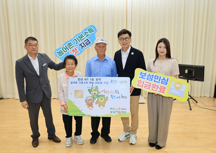 [전남광주=뉴시스] 김철우(오른쪽에서 두번째) 보성군수가 28일 겸백면민의 날 행사장에서 농어촌 기본소득 첫 지급을 기념해 지역 장수 노인 부부에게 보성사랑상품권 카드 모형을 전달하고 있다. (사진=보성군 제공) 2026.08.28. photo@newsis.com *재판매 및 DB 금지