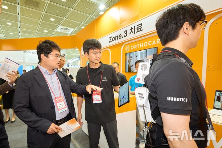 [서울=뉴시스] 이창재 대웅제약 대표가 KHF 2026 대웅 얼라이언스에서 착용형 보행재활 로봇 ‘H-Medi’를 살펴보고 있다. (사진=대웅제약 제공) 2026.08.30. photo@newsis.com
