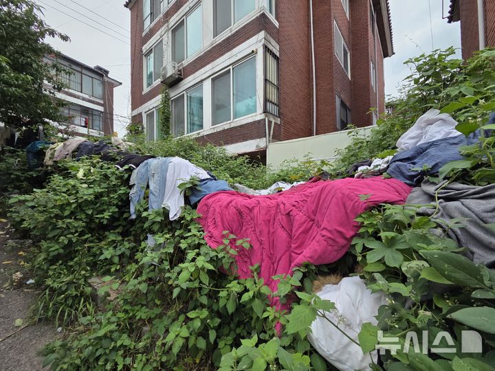 [서울=뉴시스] 고선영 수습 기자 = 지난 26일 서울 마포구 아현동의 한 주택 주변에 잡초가 무성하게 자란 가운데 옷가지와 비닐봉지 등이 곳곳에 놓여 있다. 2026.08.26. sunzero@newsis.com