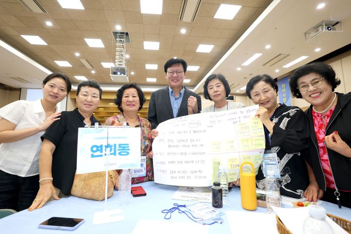 [서울=뉴시스] 8월 27일 구청 6층 대강당에서 열린 서대문구 ‘동 복지의제 발굴 워크숍’에서 연희동 지역사회보장협의체 위원들이 박운기 서대문구청장(가운데)과 함께 자신들이 발굴한 복지의제 결과물을 들어 보이고 있다. (사진=서대문구 제공) 2026.08.30. photo@newsis.com *재판매 및 DB 금지