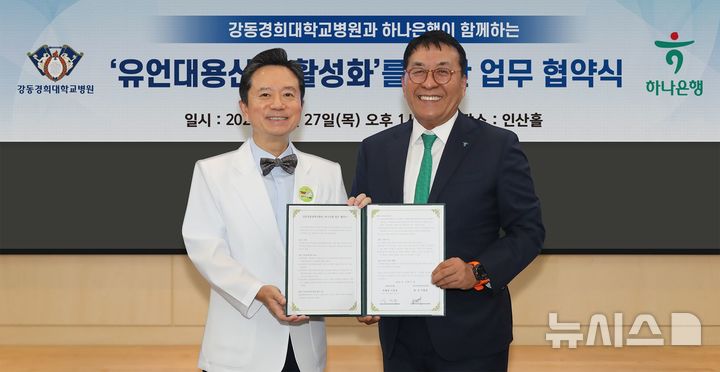 [서울=뉴시스]하나은행은 지난 27일 오후 서울 강동경희대학교병원에서 '유언대용신탁 활성화'를 위한 업무협약을 체결했다. 이날 협약식에 참석한 김진우 자산관리그룹 부행장(사진 오른쪽)이 이형래 강동경희대학교병원장(사진 왼쪽)과 함께 협약서를 들고 기념촬영을 하고 있다. (사진=하나은행 제공). 2026.08.31. photo@newsis.com 