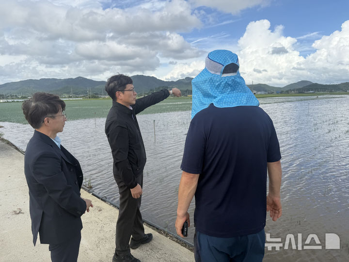 [영광=뉴시스] 이광일 농협전남지역본부장(가운데)이 31일 영광군 백수읍 일대 집중호우 피해 농가를 방문해 침수된 농경지와 농작물 생육 상태를 살펴보고 농업인 애로사항을 청취하고 있다. (사진=전남농협 제공) photo@newsis.com *재판매 및 DB 금지