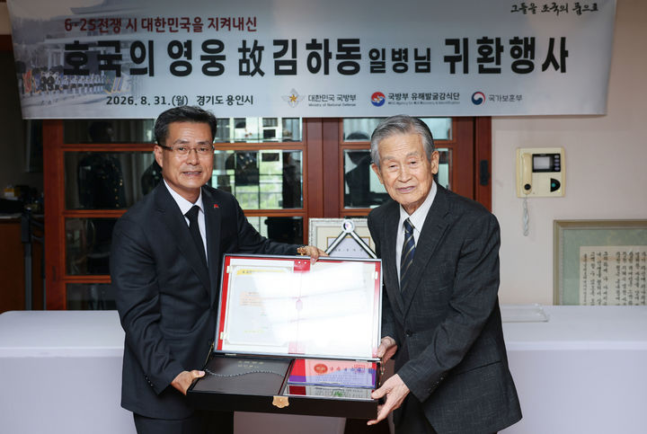 [서울=뉴시스] 홍효식 기자 = 31일 오전 경기도 용인에서 열린 6·25전쟁 호국영웅 고 김하동 일병의 귀환 행사에서 전병희 국방부 유해발굴감식단장(왼쪽)이 유가족 대표인 고 김하동 일병의 남동생 김하준 옹(오른쪽, 87세)에게 호국의 얼 함을 전달하고 있다. (사진=국방부 제공) 2026.08.31. photo@newsis.com *재판매 및 DB 금지