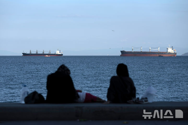 [AP/뉴시스] 자료사진으로 튀르키예 이스탄불 앞 마르마라해에서 보스포러스해협을 건너려는 선박들이 닻을 내리고 있고 화물선들 앞 작은배에 사람이 타고 있다 