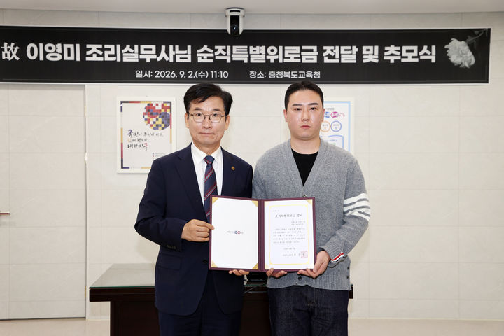윤건영 충북도교육감(왼쪽)이 2일 집무실에서 고 이영미 조리실무사 유족에 위로금을 전달하고 기념촬영을 하고 있다.(사진=충북교육청 제공) *재판매 및 DB 금지