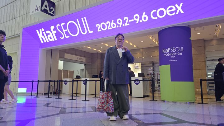 [사진=박현주 미술전문기자] 정구호 디렉터가 ‘키아프 서울 2026’ 전시장 입구에 서 있다. 키아프의 주조색인 연초록과 보라색이 입구를 환하게 물들이고 있다. *재판매 및 DB 금지