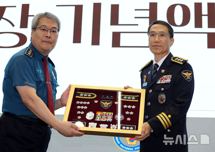 [서울=뉴시스] 홍효식 기자 = 유재성(오른쪽) 경찰청장 직무대행이 2일 서울 서대문구 경찰청에서 열린 이임식에서 홍석기 국가수사본부장에게 계급장 기념액자를 전달받은 뒤 기념촬영하고 있다. 2026.09.02. yesphoto@newsis.com