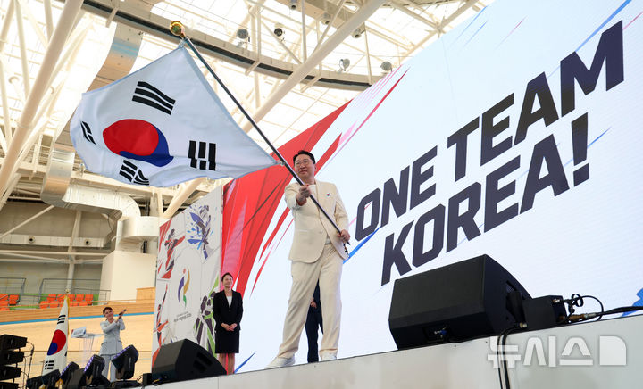 [진천=뉴시스] 이영환 기자 = 이상현 선수단장이 3일 오후 충북 진천국가대표선수촌 벨로드롬에서 열린 2026 아이치-나고야 하계아시아경기대회 대한민국 선수단 결단식에서 단기를 흔들고 있다. 2026.09.03. 20hwan@newsis.com