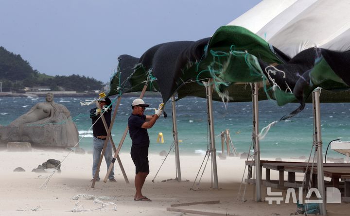 [제주=뉴시스] 우장호 기자 = 제24호 태풍 '크로반'의 간접영향으로 강한 바람이 부는 4일 오전 제주시 한림읍 협재해수욕장에서 마을 관계자들이 강풍 피해에 대비해 차양막 철거 작업을 하고 있다. 제주 지정 해수욕장 12곳은 오는 6일 일제히 문을 닫을 예정이었지만, 태풍 영향에 따른 풍랑특보로 해수욕이 금지돼 사실상 이날 폐장하는 분위기다. 2026.09.04. woo1223@newsis.com