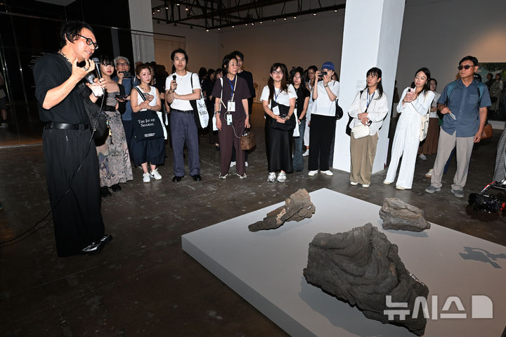 [전남광주=뉴시스] 이영주 기자 = 호추니엔(Ho Tzu Nyen·왼쪽) 제16회 광주비엔날레 예술감독이 4일 오후 전남광주 북구 운암동 광주비엔날레 전시관에서 관람객들을 대상으로 제주도 화산암 작품을 설명하고 있다. 광주비엔날레는 제주도 화산암이 형성되는 과정에서 겪은 '변화'가 비엔날레의 주제와 맞닿아 있다며 핵심 전시물로 꼽고 있다. 제16회 광주비엔날레는 "너는 네 삶을 바꿔야 한다"를 주제로 오는 5일부터 11월15일까지 72일간 열린다. 2026.09.04. leeyj2578@newsis.com