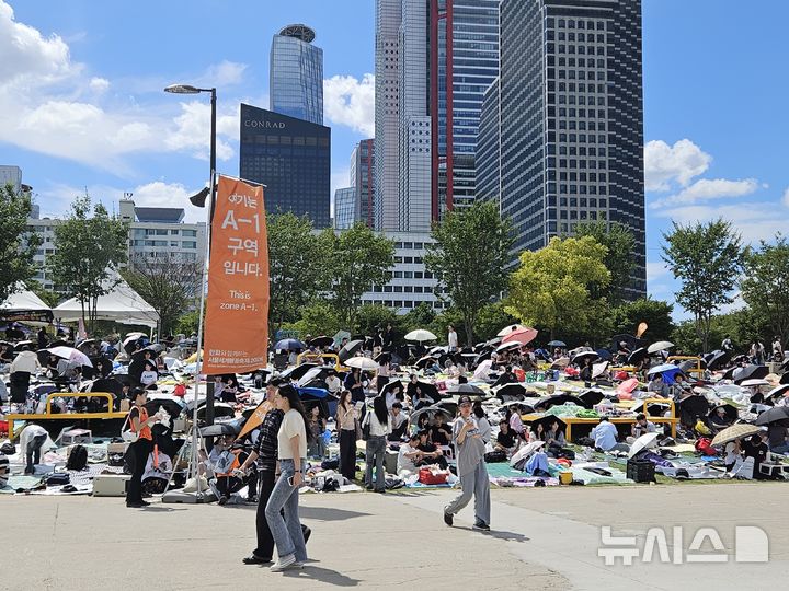 [서울=뉴시스] 염지윤 수습기자 = 5일 서울 영등포구 여의도 한강공원에서 '서울세계불꽃축제 2026'을 기다리는 시민들이 돗자리를 펴고 우산과 양산으로 햇볕을 피하고 있다. 2026.09.05. yeomjy@newsis.com