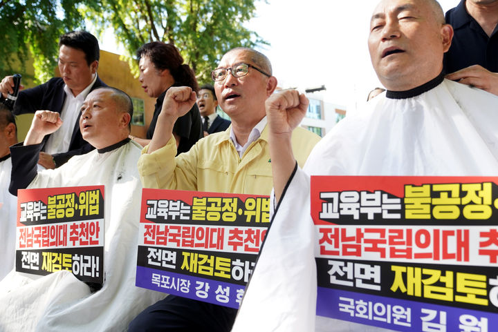 [목포=뉴시스] 더불어민주당 김원이 의원과 강성휘 목포시장, 최선국 전남광주특별시의원 등이 5일 오후 서울 청와대 앞에서 '위법·불공정한 전남 국립의대 추천 전면 재검토'를 촉구하며 삭발을 하고 있다. (사진=목포시 제공) 2026.09.05. photo@newsis.com *재판매 및 DB 금지