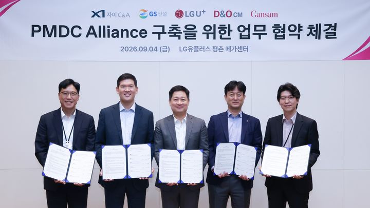 [서울=뉴시스] LG유플러스는 GS건설, 자이C&A, 간삼건축, D&O CM과 '사전제작형 모듈러 데이터센터(PMDC) 얼라이언스 구축을 위한 업무협약'을 체결했다고 6일 밝혔다. 사진은 지난 4일 평촌메가센터에서 열린 'PMDC 얼라이언스 구축을 위한 업무협약식'에서 (왼쪽부터) 김욱수 자이C&A대표, 허윤홍 GS건설 대표, 홍범식 LG유플러스 대표, 이영호 D&O CM 대표, 박무찬 간삼건축 총괄대표가 기념사진을 촬영하고 있는 모습. 2026.09.06. (사진=LG유플러스 제공) *재판매 및 DB 금지