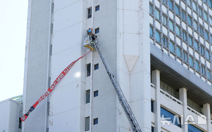 [서울=뉴시스] 김선웅 기자 = 양규서 민주노총 공공운수노조 조직국장이 6일 서울 중구 소재 전국민주노동조합총연맹 입주 건물에서 고공농성을 하며 아내가 당한 노조활동가 부당해고 및 문제 제기 과정에서 발생한 자신의 정직 처분을 규탄하고 있다. 2026.09.06. mangusta@newsis.com