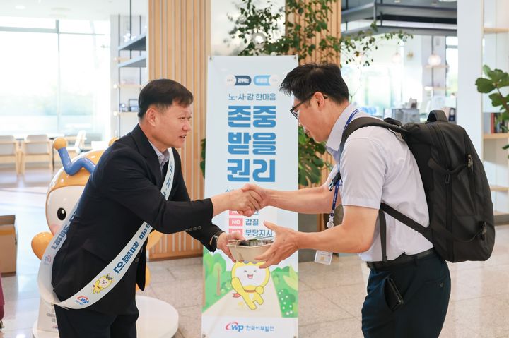 [세종=뉴시스]한국서부발전은 7일 충남 태안 본사를 포함한 전국 12개 사업장에서 노사감 합동으로 ‘존중받을 권리 실현’ 캠페인을 동시에 진행했다고 밝혔다. 사진은 이정복 서부발전 사장(왼쪽)이 직원에게 출근길 다과를 전달하는 모습이다.(사진= 서부발전 제공) *재판매 및 DB 금지
