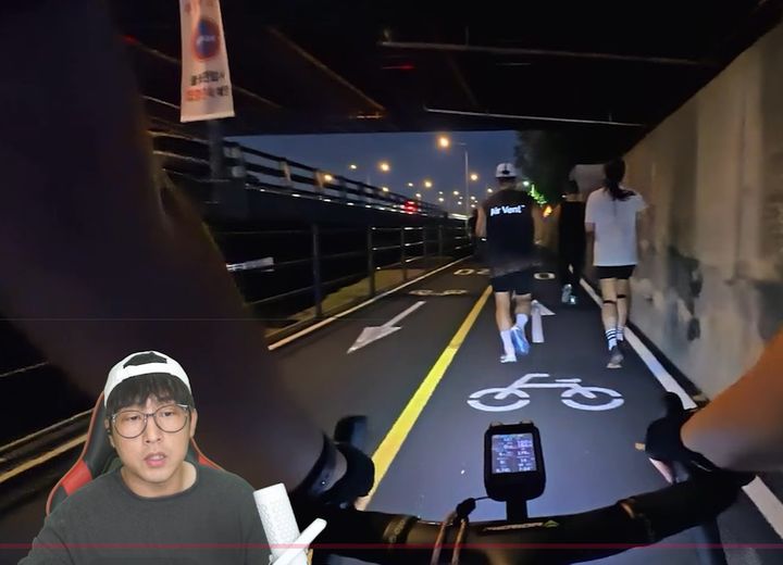 [서울=뉴시스]인도 폭이 충분히 넓음에도 불구하고 러너들은 자전거도로로 내려와 통행을 가로막았으며, 뒤따라오는 자전거가 경적을 울리거나 라쳇 소리를 내며 신호를 보내도 대열을 비켜주지 않았다.&nbsp; 사진 유튜브 채널 '드론라이더' 영상 캡처 *재판매 및 DB 금지