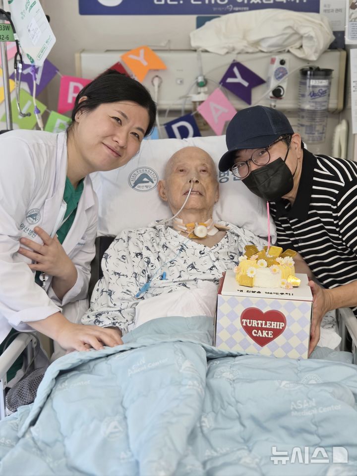 [서울=뉴시스] 구민정 서울아산병원 심장혈관흉부외과 교수와 이승만 환자·보호자(왼쪽부터)가 수술 후 병실에서 맞은 이씨의 100번째 생일을 축하하며 기념촬영을 하고 있다. (사진= 서울아산병원 제공) 