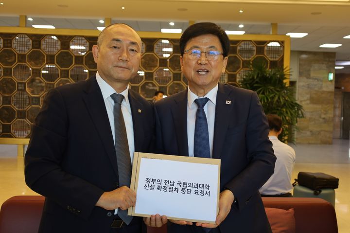 [목포=뉴시스]더불어민주당 김원이 국회의원이 8일 오전 국회에서 최교진 교육부장관을 만나 정부의 전남 국립의과대학 신설 확정절차 중단 요청서를 직접 전달하고 있다. (사진=김원이 국회의원실 제공) 2026.09.08. photo@newsis.com *재판매 및 DB 금지