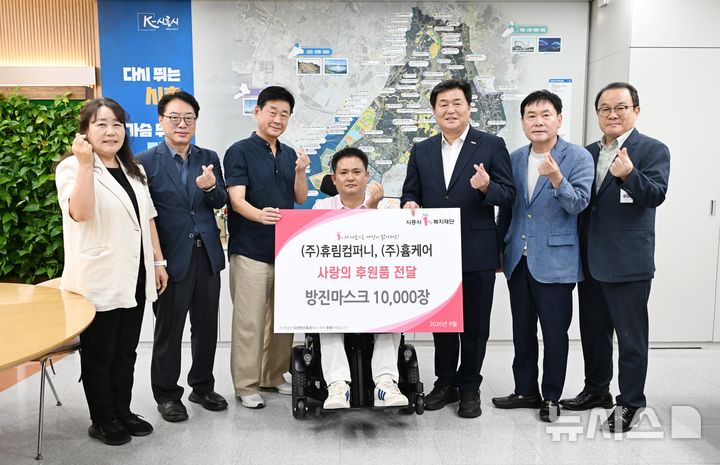 [시흥=뉴시스] 방진마스크 1만장 기부식 참석자들이 기념 촬영을 하고 있다. (사진=시흥시 제공).2026.09.08. photo@newsis.com