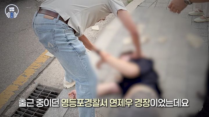 [서울=뉴시스] 지난 7월6일 경기도의 한 건물 앞에서 한 남성이 갑자기 발작을 일으키며 쓰러지자 출근 중이던 영등포경찰서 연제우 경장이 응급조치에 나서고 있다. (사진=유튜브 채널 '서울경찰' 캡처) *재판매 및 DB 금지