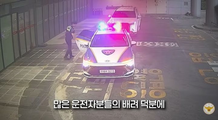 [서울=뉴시스] 퇴근길 교통 정체 속 경찰이 고열 증세를 보인 13개월 아기를 순찰차로 병원에 긴급 이송하고 있다. (사진='대한민국 경찰청' 캡처)
