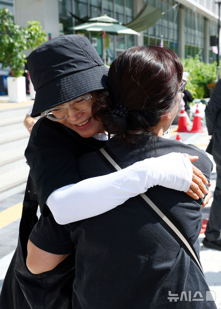 [서울=뉴시스] 전신 기자 = 학교 내 성폭력 의혹을 제보한 후 전보 및 해임됐던 지혜복 교사가 9일 서울 용산구 서울시교육청 앞에서 열린 복직 입장 발표 기자회견에 앞서 참석자들과 포옹하고 있다. 2026.09.09. photo1006@newsis.com