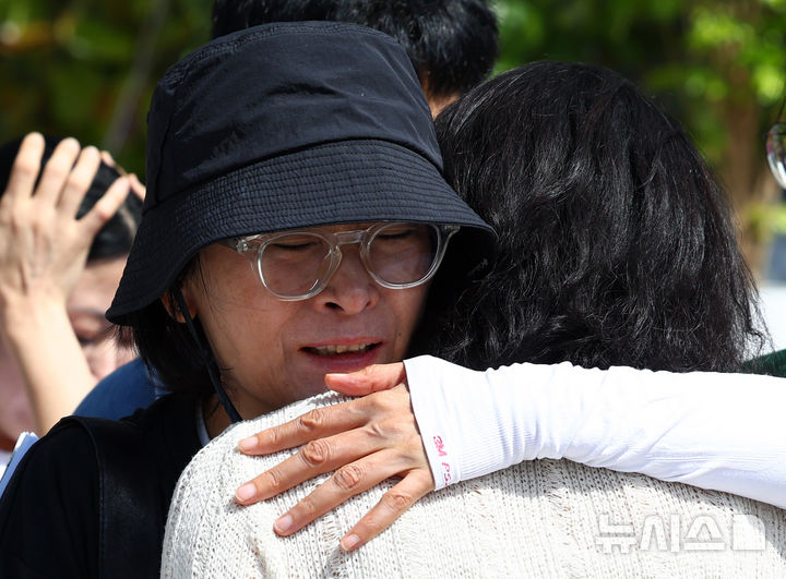 [서울=뉴시스] 전신 기자 = 학교 내 성폭력 의혹을 제보한 후 전보 및 해임됐던 지혜복 교사가 9일 서울 용산구 서울시교육청 앞에서 열린 복직 입장 발표 기자회견에 앞서 참석자들과 포옹하고 있다. 2026.09.09. photo1006@newsis.com
