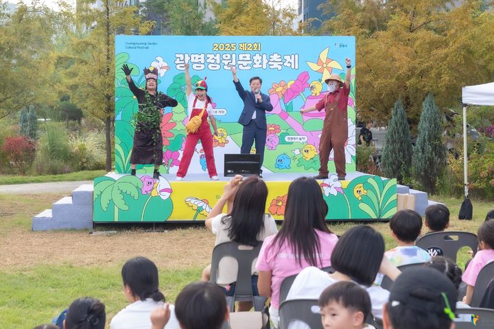 [광명=뉴시스] 2025년 일직동 새빛공원에서 열린 광명정원문화축제. 박승원 광명시장(사진 오른쪽에서 두 번째)이 진행자들과 퍼포먼스를 함께 하고 있다. (사진=광명시 제공) 2026.09.10. photo@newsis.com *재판매 및 DB 금지