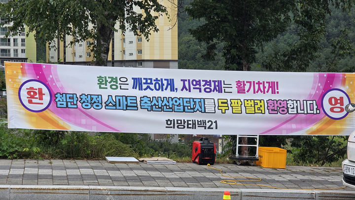 10일 태백시청 앞에서 ‘태백 스마트 축산단지 반대 삼척 범시민공동대책위원회’가 집회를 열고 사업 철회를 촉구하는 가운데 인근에 부착된 스마트 축산단지 유치 환영 현수막.(사진=뉴시스) *재판매 및 DB 금지