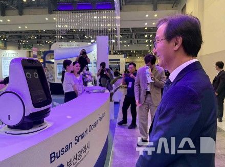 [부산=뉴시스]전재수 부산시장이 지난 9일 부산 벡스코 제1전시장에서 열린 '2026 월드 스마트시티 엑스포' 개막식 후 부산 스마트오션관을 찾아 신성델타테크의 AI 반려로봇 '레미'와 대화하고 있다.(사진=신성델타테크 제공) 2026.09.10. photo@newsis.com