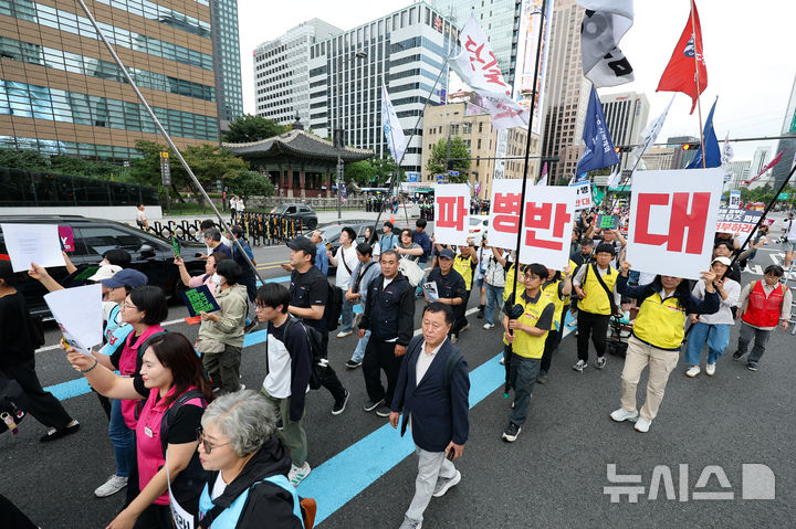 [서울=뉴시스] 황준선 기자 = 12일 서울 종로구 세종대로 사거리 인근에서 열린 '미국은 침략전쟁 중단하라! 정부는 호르무즈 파병 단호히 거부하라! 시민 대행진'에서 참석자들이 청와대를 향해 행진하고 있다. 2026.09.12. hwang@newsis.com